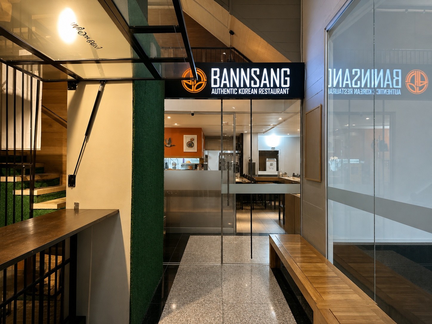 The glass front and lit BannSang sign, seen from the High Street walkway